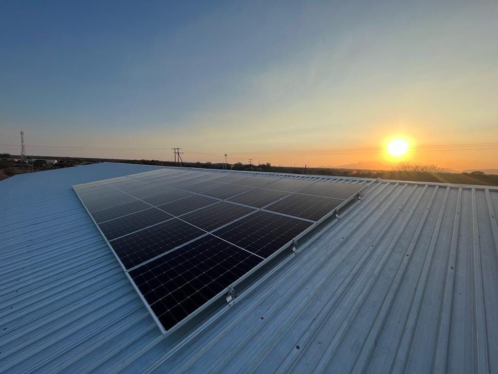 Roof-mounted panels on a steel roof at sunset